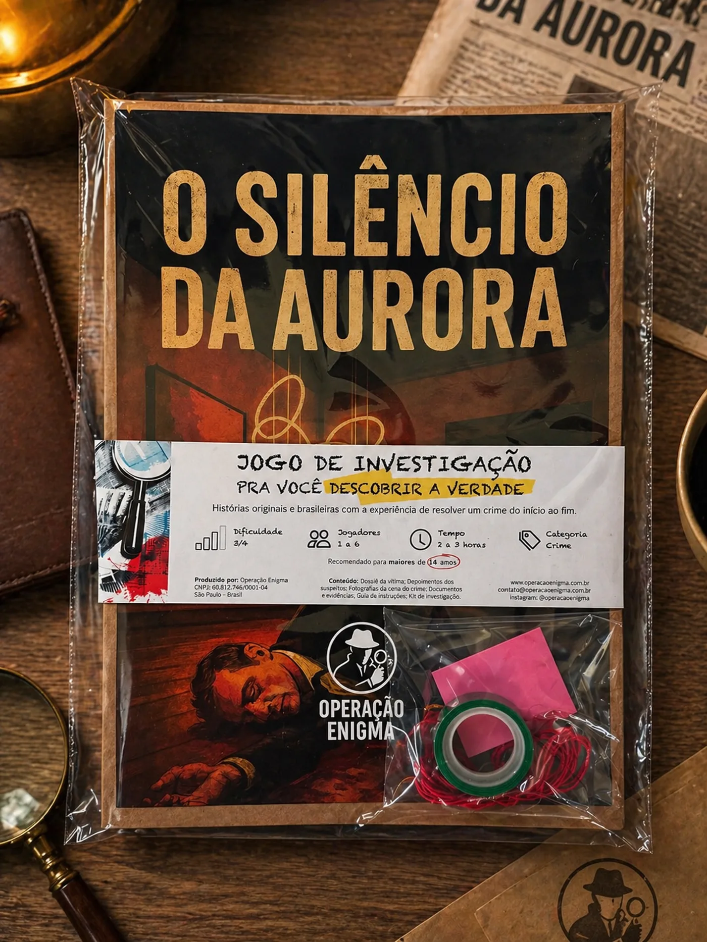 O dossiê de O Silêncio da Aurora sobre a mesa, embalado no plástico com a cinta, com o Kit do Agente à vista.